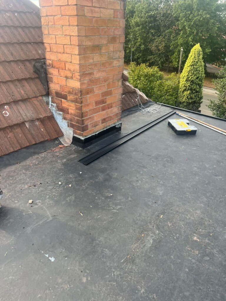 This is a photo of a flat roof which has just been repaired, there is also a chimney stack and some leadwork has also been dressed. Works carried out by LJ Roofing Penhill